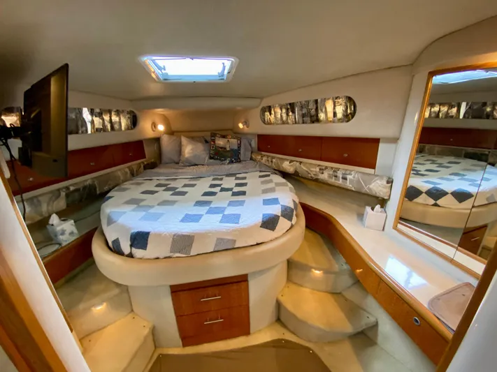  Yacht Photos Pics Luxurious cabin interior of 1996 Sea Ray 450 Sundancer yacht with cozy bed and elegant decor.