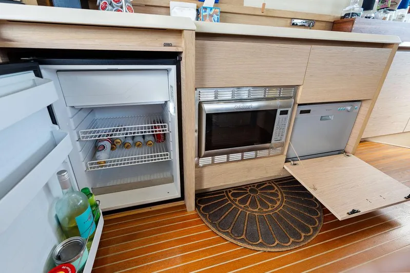Have Another Yacht Photos Pics Compact kitchen area on a 2016 Beneteau Monte Carlo 4 yacht with fridge, microwave, and dishwasher.