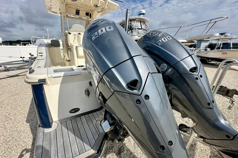  Yacht Photos Pics 2024 Scout 277 LXF boat with dual 200 horsepower engines, docked under cloudy skies.