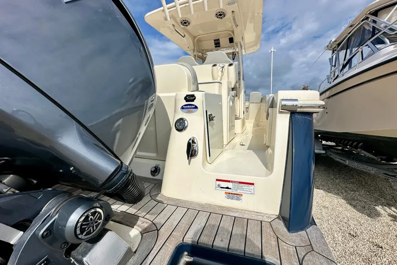 Yacht Photos Pics 2024 Scout 277 LXF boat with Yamaha engine, showcasing deck and seating area.