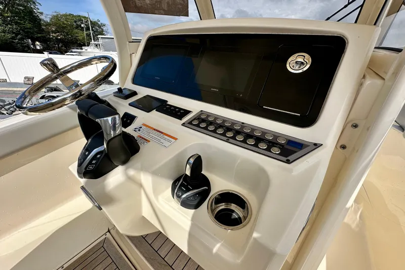  Yacht Photos Pics 2024 Scout 277 LXF boat dashboard with steering wheel and control panel.