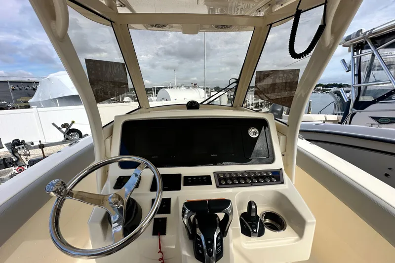  Yacht Photos Pics 2024 Scout 277 LXF boat dashboard with steering wheel and control panel.