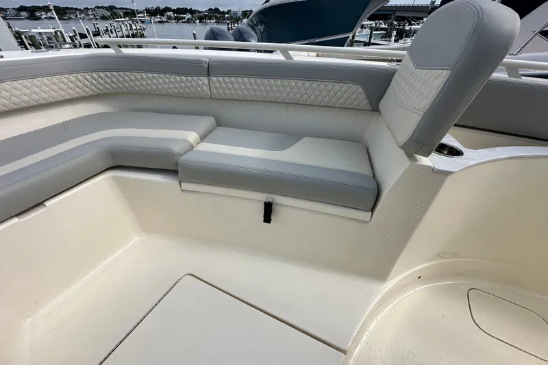  Yacht Photos Pics 2024 Scout 277 LXF boat interior with cushioned seating and waterfront view.