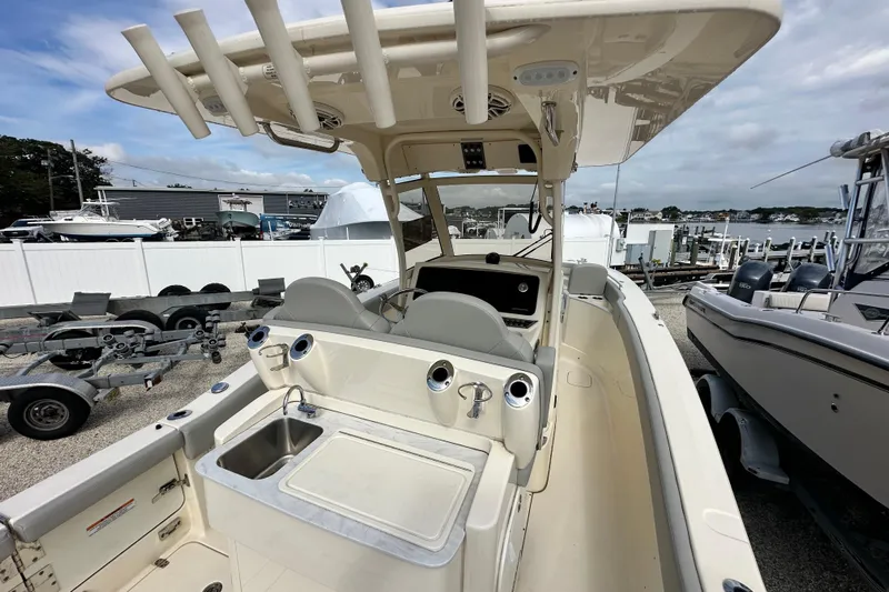  Yacht Photos Pics 2024 Scout 277 LXF boat interior with helm, seating, and sink at marina.