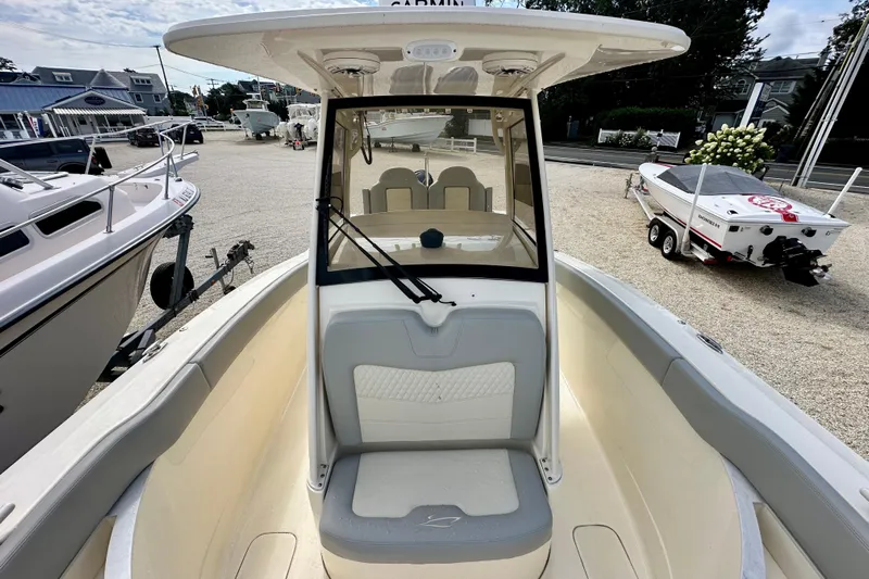  Yacht Photos Pics 2024 Scout 277 LXF boat interior with seating and windshield, displayed outdoors.