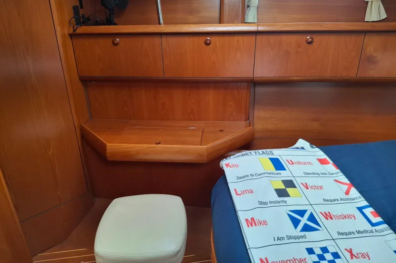 Majestic Yacht Photos Pics Interior of 2009 Jeanneau Sun Odyssey 54 DS with wooden cabinetry and nautical flag chart.