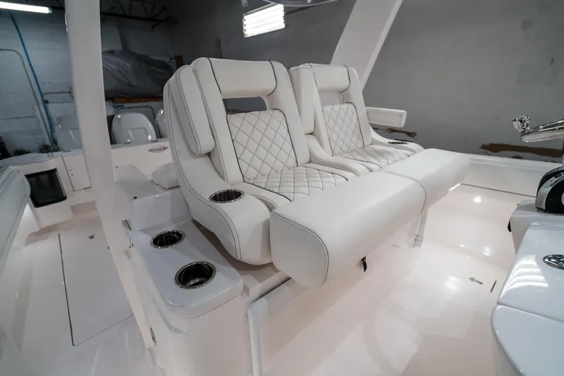 Tighten Up Yacht Photos Pics Luxurious seating on 2020 Intrepid 407 Panacea boat, featuring white quilted upholstery and cup holders.