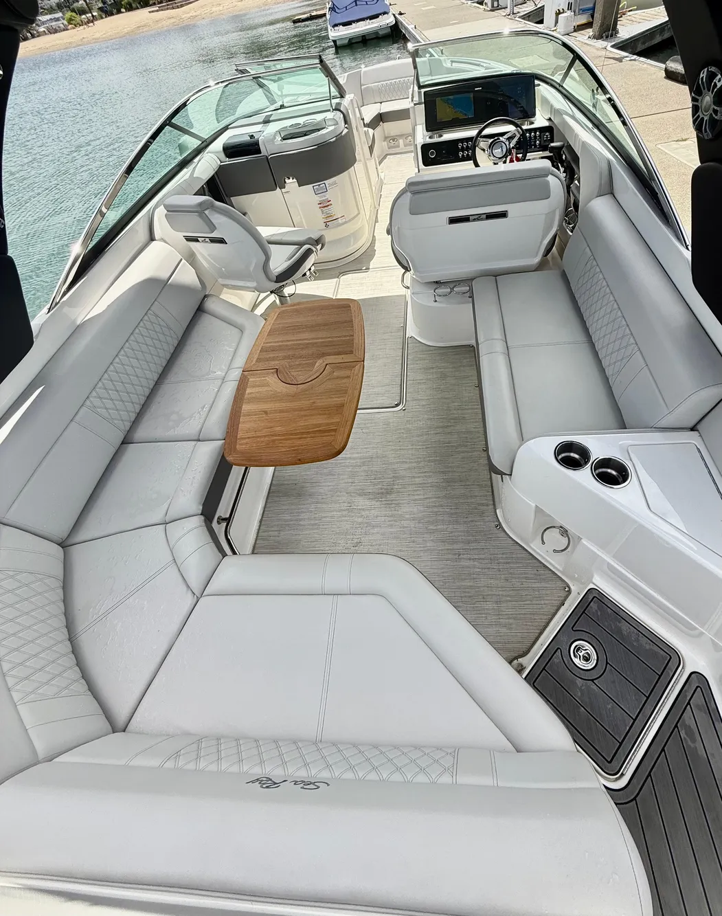 2020 Sea Ray SLX 280 boat interior with luxurious seating and wooden table.