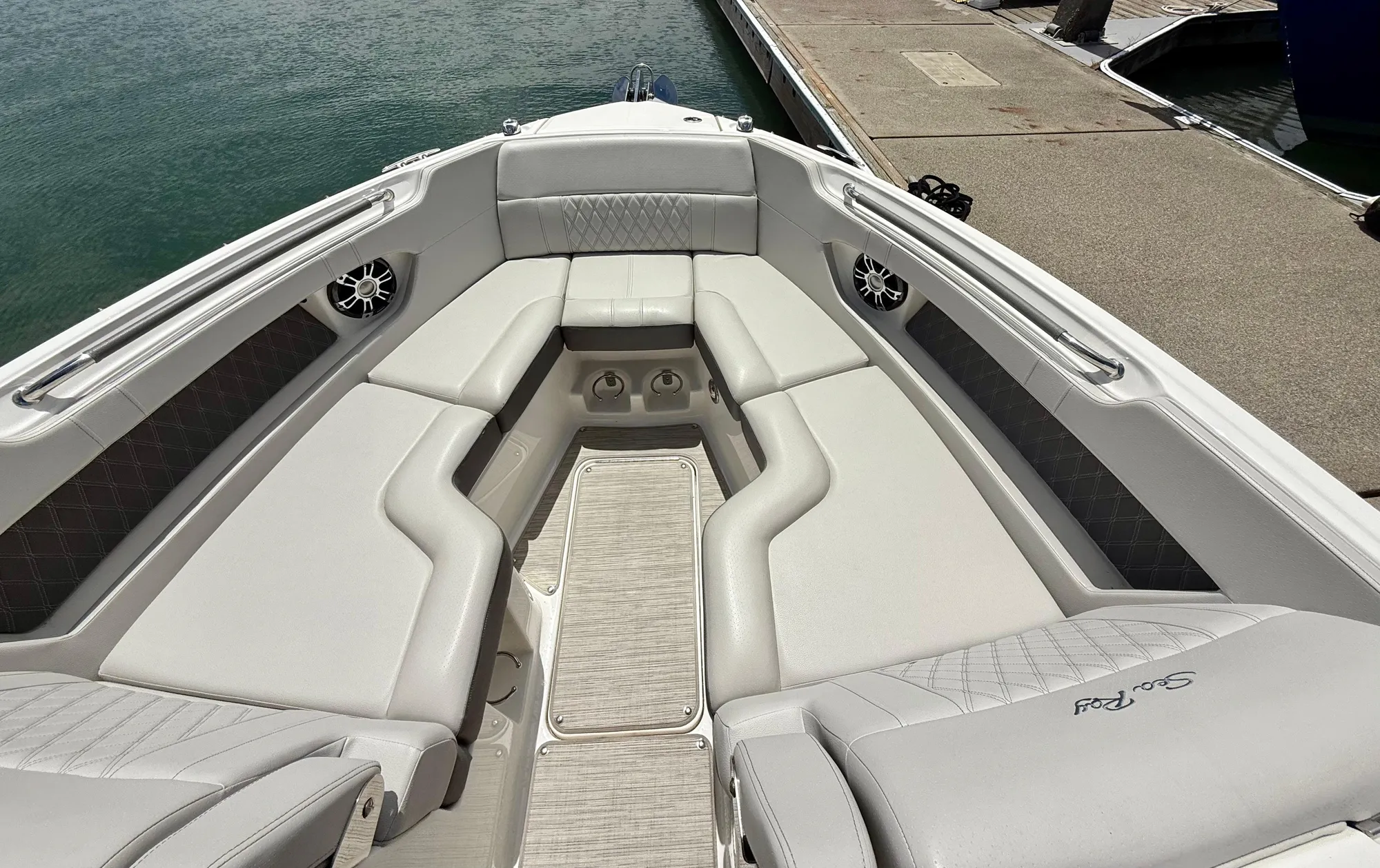 2020 Sea Ray SLX 280 boat interior with luxurious seating and speakers, docked by the water.