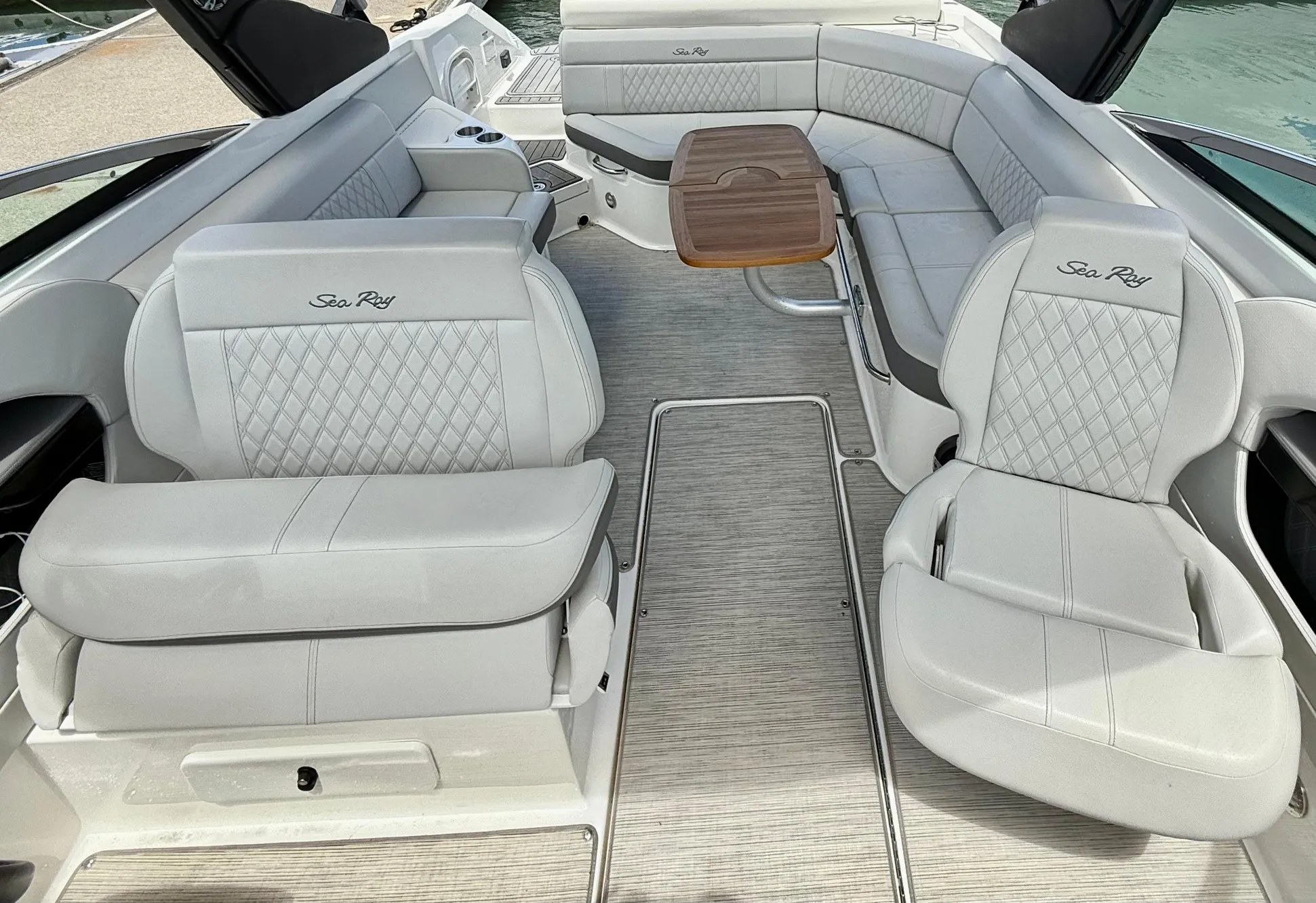 2020 Sea Ray SLX 280 boat interior with luxurious seating and wooden table.