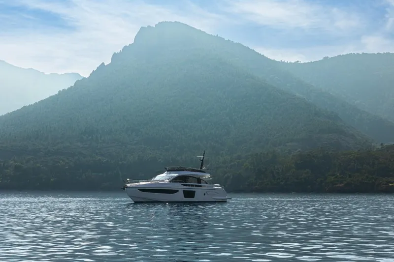  Yacht Photos Pics 2023 Azimut S7 yacht cruising on serene waters with mountainous backdrop.