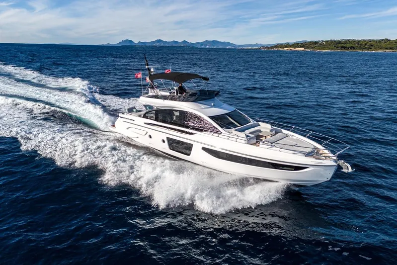  Yacht Photos Pics 2023 Azimut S7 yacht cruising on open sea with scenic coastline backdrop.