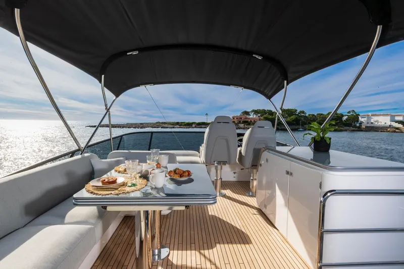  Yacht Photos Pics Luxurious 2023 Azimut S7 yacht deck with dining setup, overlooking serene waters.
