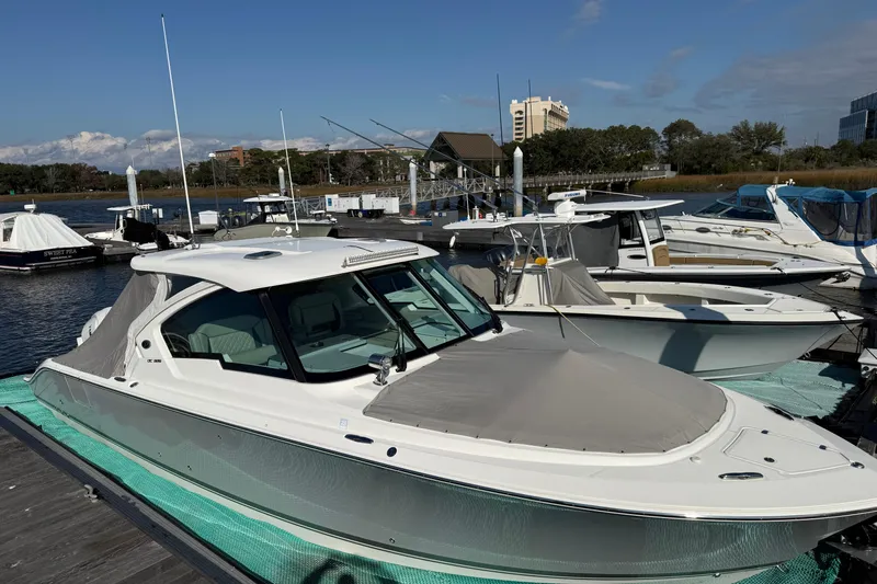  Yacht Photos Pics 2023 Pursuit DC 326 Dual Console boat docked at marina under clear blue sky.