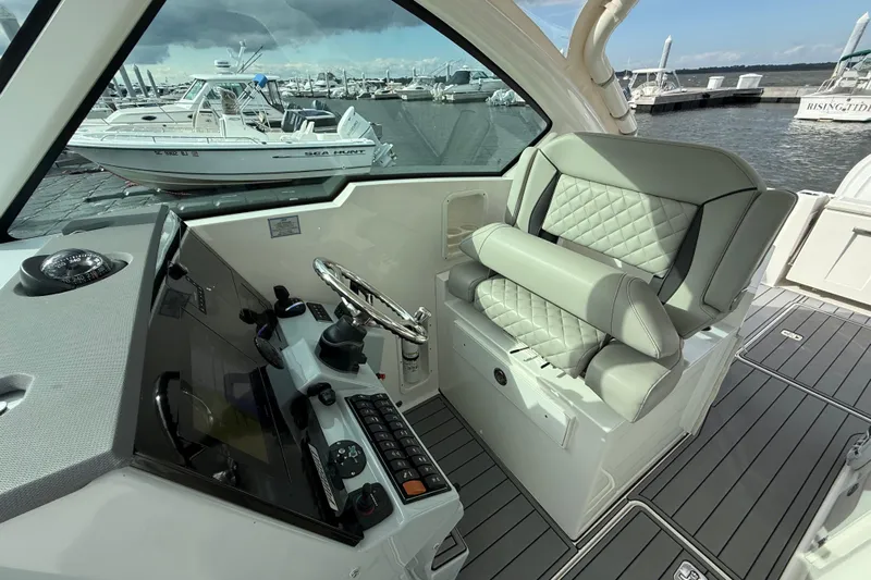  Yacht Photos Pics 2023 Pursuit DC 326 Dual Console boat interior with helm and seating at marina.