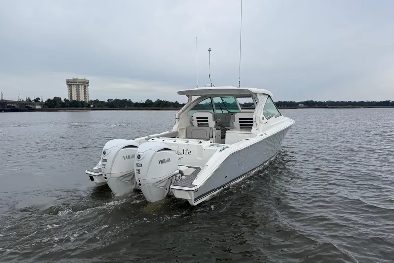  Yacht Photos Pics 2023 Pursuit DC 326 Dual Console boat with twin Yamaha engines on a calm waterway.