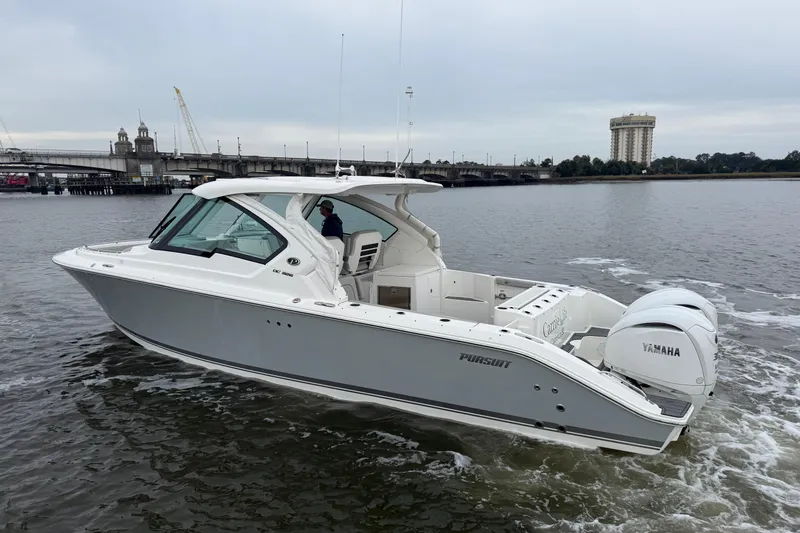  Yacht Photos Pics 2023 Pursuit DC 326 Dual Console boat cruising on a river with bridge in background.