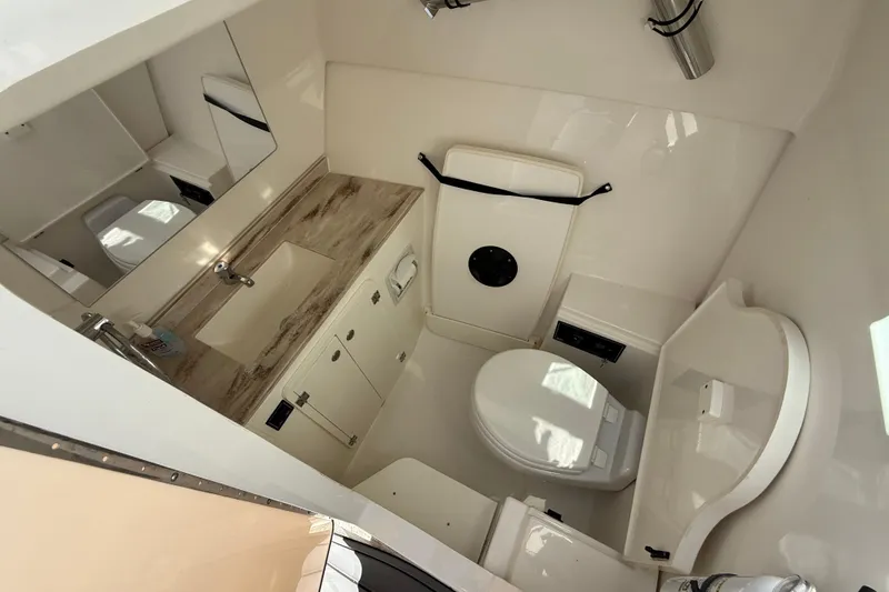  Yacht Photos Pics 2023 Pursuit DC 326 Dual Console boat bathroom with sink, toilet, and storage cabinets.