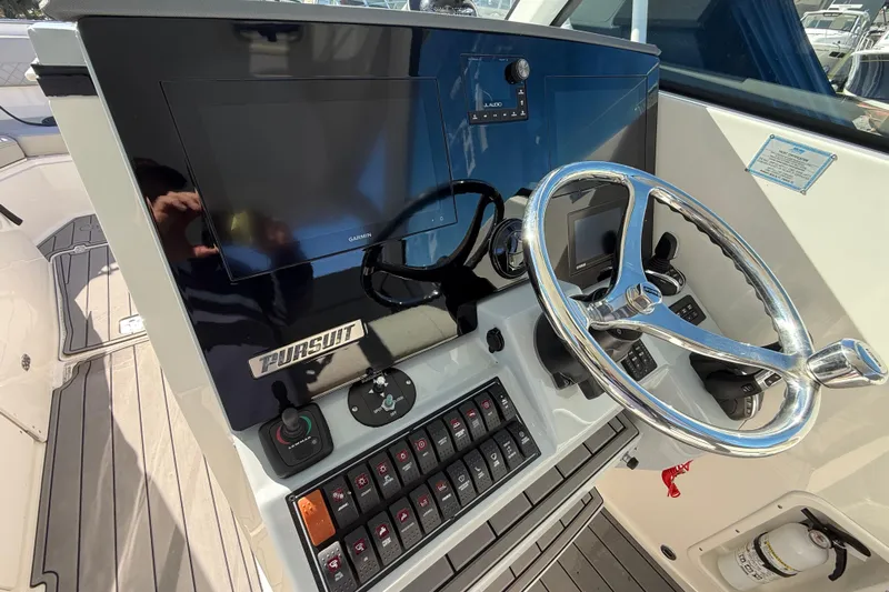  Yacht Photos Pics 2023 Pursuit DC 326 Dual Console boat dashboard with steering wheel and controls.