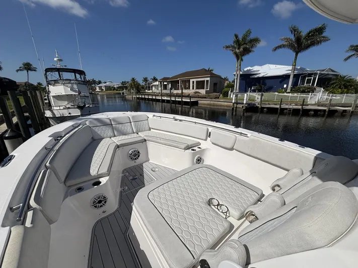  Yacht Photos Pics 2023 Sea Fox 328 Commander boat with spacious seating, docked by waterfront homes.