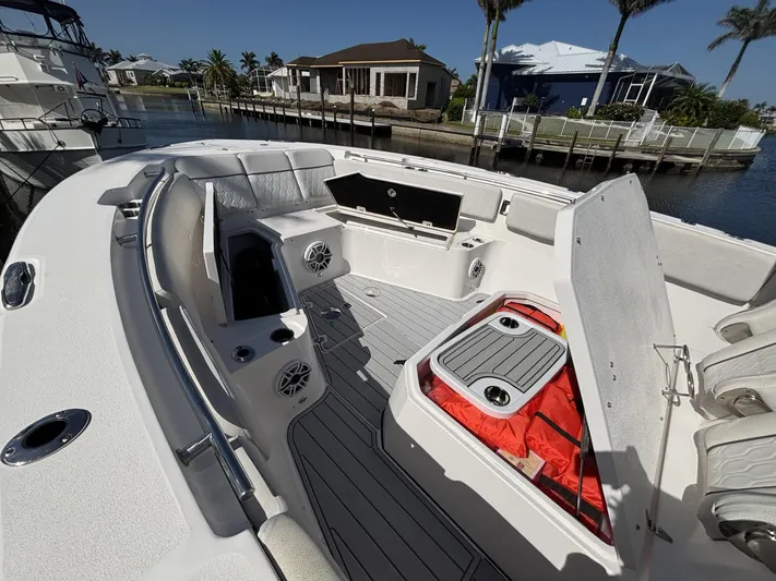  Yacht Photos Pics 2023 Sea Fox 328 Commander boat interior with seating and storage, docked by waterfront homes.