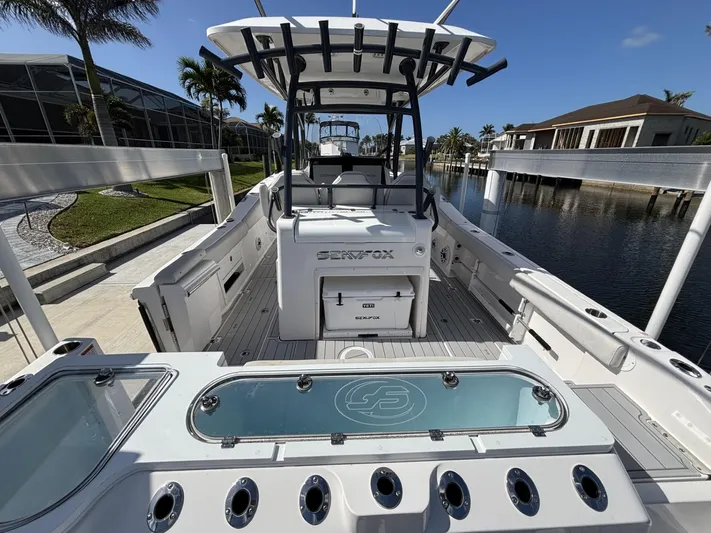  Yacht Photos Pics 2023 Sea Fox 328 Commander boat with spacious deck and modern amenities, docked by waterfront homes.