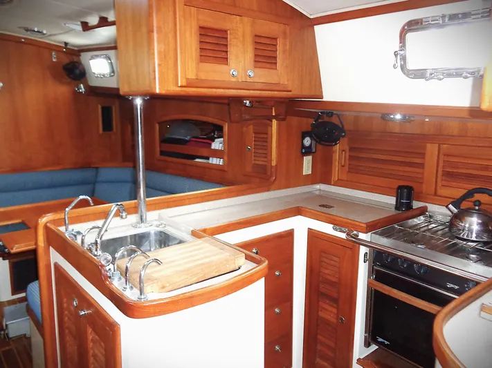 Azure Yacht Photos Pics Interior of 2005 Pacific Seacraft 40 sailboat with wooden cabinetry and compact kitchen.