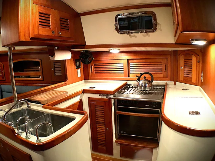 Azure Yacht Photos Pics Luxurious 2005 Pacific Seacraft 40 yacht kitchen with wood cabinetry and modern appliances.