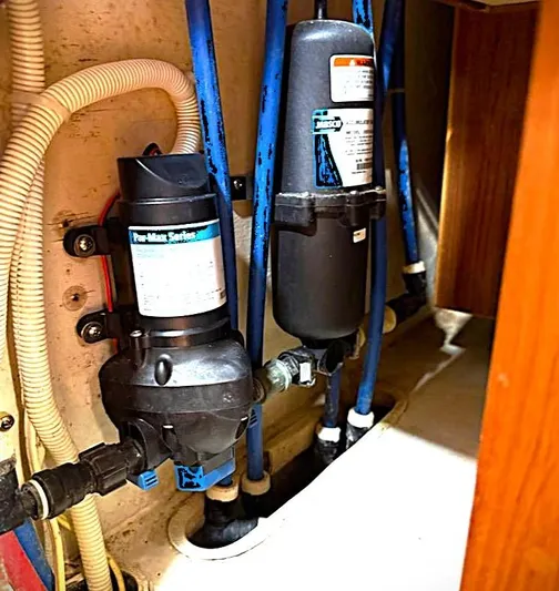 Azure Yacht Photos Pics Plumbing system in a 2005 Pacific Seacraft 40 sailboat, featuring pumps and blue tubing.
