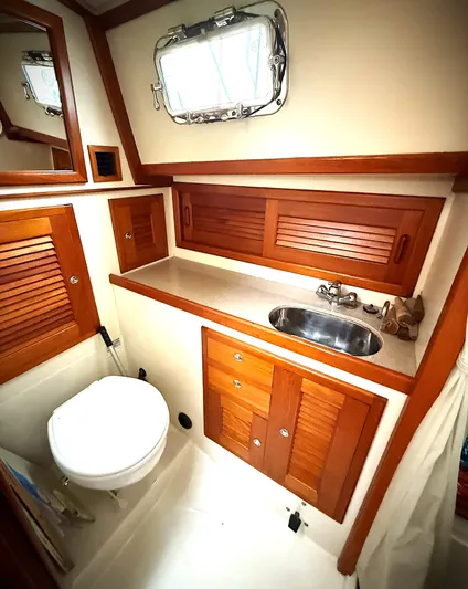 Azure Yacht Photos Pics 2005 Pacific Seacraft 40 yacht bathroom with wooden cabinets and stainless steel sink.