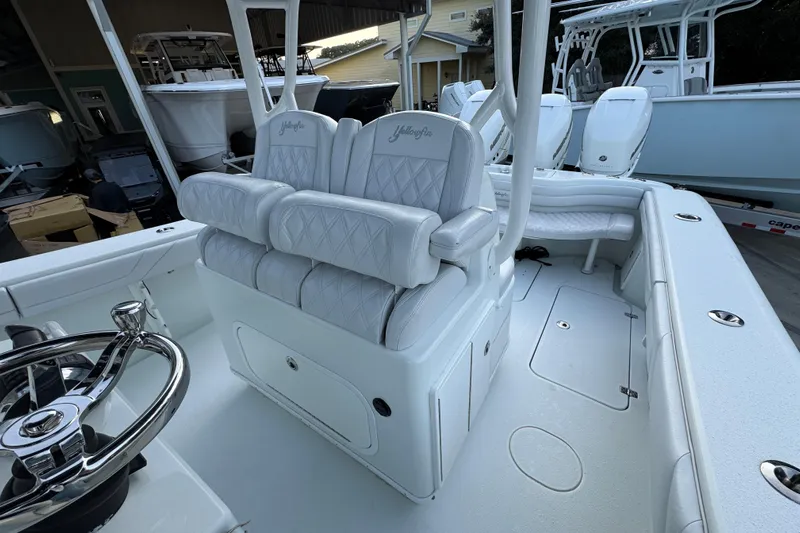  Yacht Photos Pics 2019 Yellowfin 34 Offshore boat interior with white seating and steering wheel.