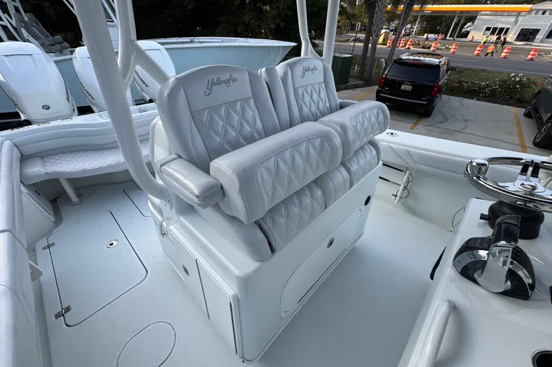  Yacht Photos Pics 2019 Yellowfin 34 Offshore boat interior with white cushioned seating and steering wheel.