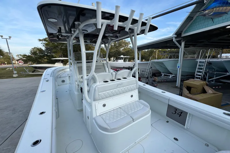  Yacht Photos Pics 2019 Yellowfin 34 Offshore boat with white seating and rod holders, docked at a marina.