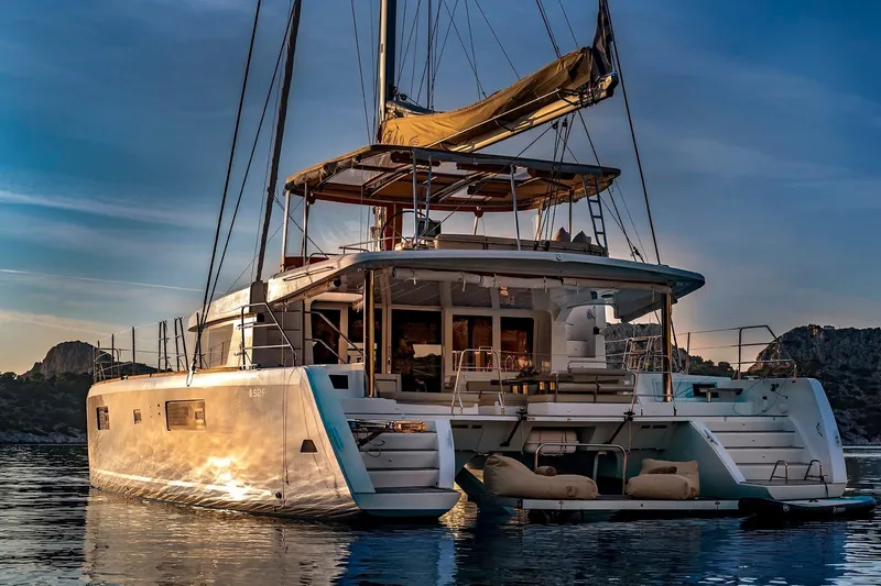  Yacht Photos Pics 2018 Lagoon 52 F catamaran at sunset, anchored in serene waters.