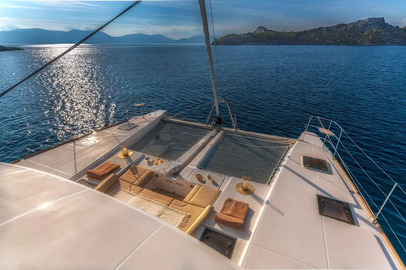 Yacht Photos Pics Luxurious 2018 Lagoon 52 F catamaran with elegant deck seating, overlooking serene ocean waters.