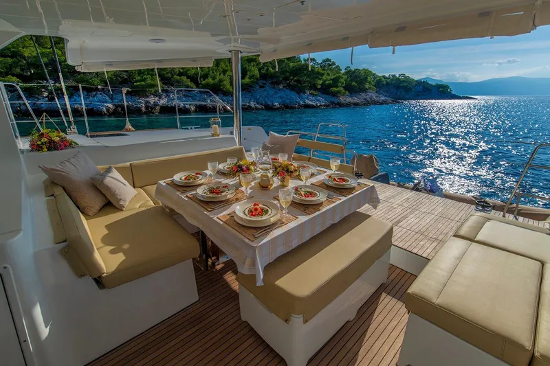  Yacht Photos Pics Luxurious Lagoon 52 F yacht dining area with elegant table setting, overlooking serene ocean view.