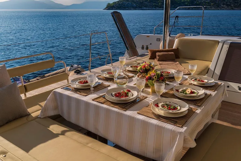  Yacht Photos Pics Luxurious dining setup on a 2018 Lagoon 52 F yacht, overlooking serene ocean views.