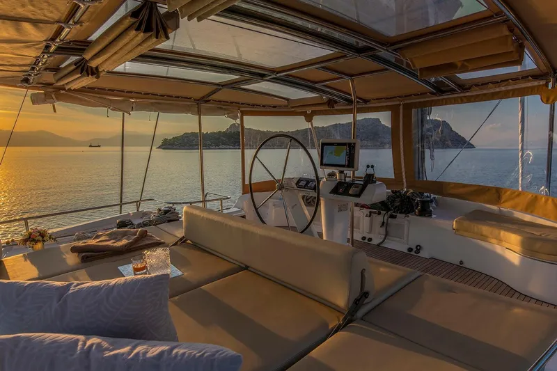  Yacht Photos Pics Luxurious 2018 Lagoon 52 F yacht interior at sunset, featuring elegant seating and navigation equipment.