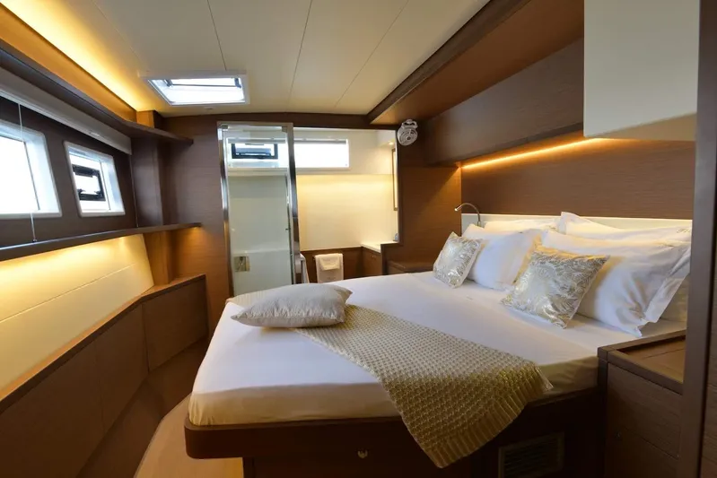  Yacht Photos Pics Luxurious cabin interior of 2018 Lagoon 52 F yacht with elegant bedding and ambient lighting.