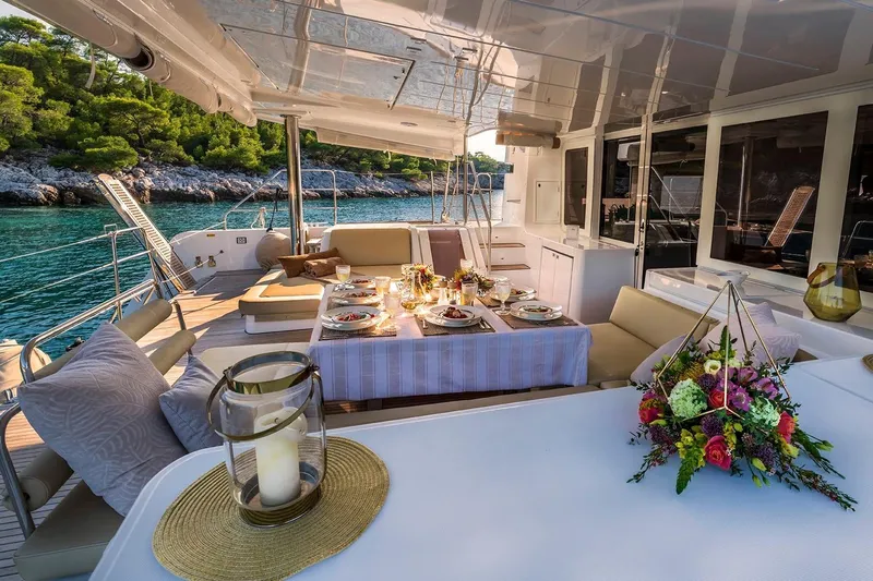  Yacht Photos Pics Luxurious 2018 Lagoon 52 F yacht deck with elegant dining setup and scenic ocean view.