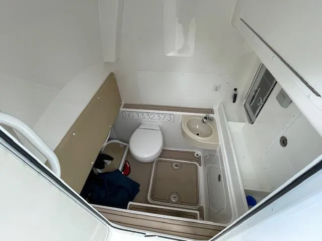  Yacht Photos Pics 2022 Invincible 36 Open Fisherman boat bathroom with toilet, sink, and storage area.