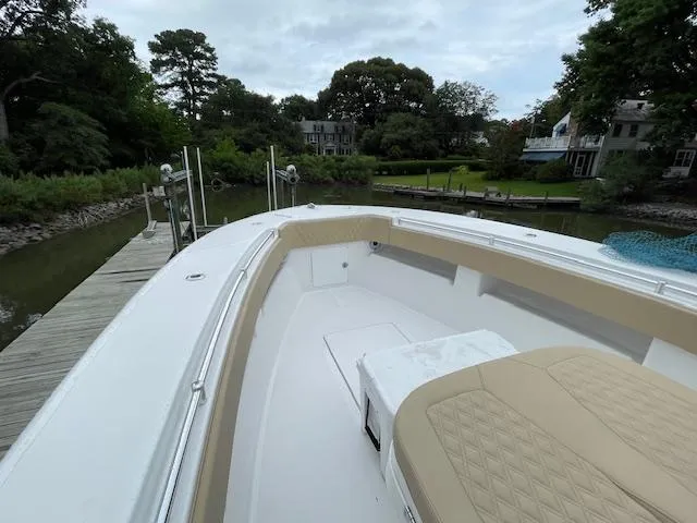  Yacht Photos Pics 2022 Invincible 36 Open Fisherman boat docked by lush greenery.