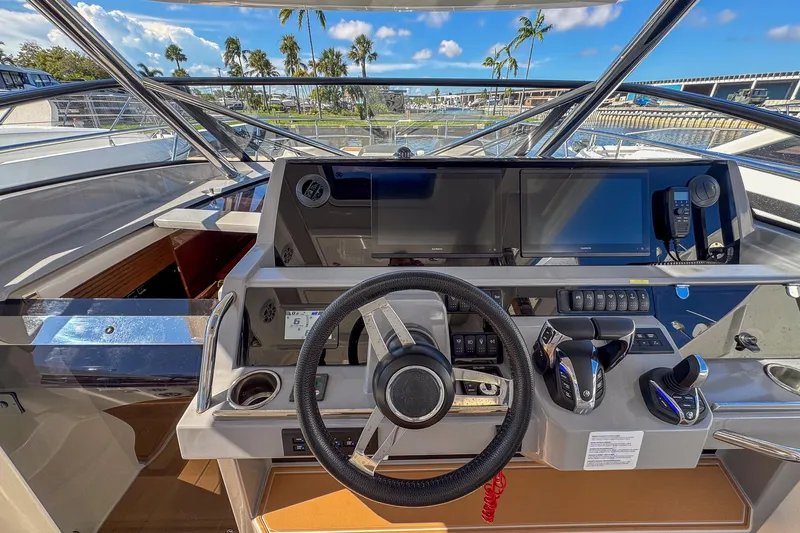 Trade In Yacht Photos Pics Cockpit of 2022 Jeanneau Leader 12.5 WA with modern navigation equipment and steering wheel.