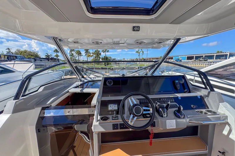 Trade In Yacht Photos Pics 2022 Jeanneau Leader 12.5 WA helm with modern controls and panoramic view.