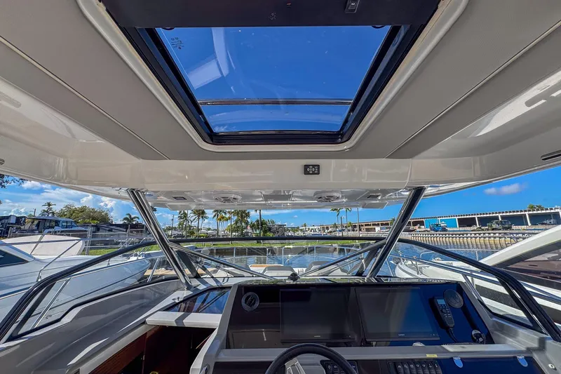 Trade In Yacht Photos Pics Interior view of 2022 Jeanneau Leader 12.5 WA boat cockpit with skylight and navigation controls.