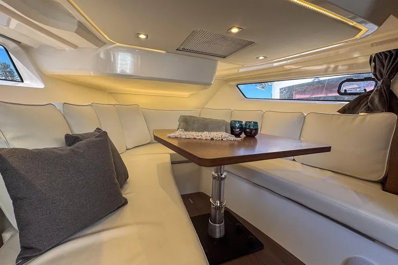 Trade In Yacht Photos Pics Luxurious interior of 2022 Jeanneau Leader 12.5 WA yacht with elegant seating and table.