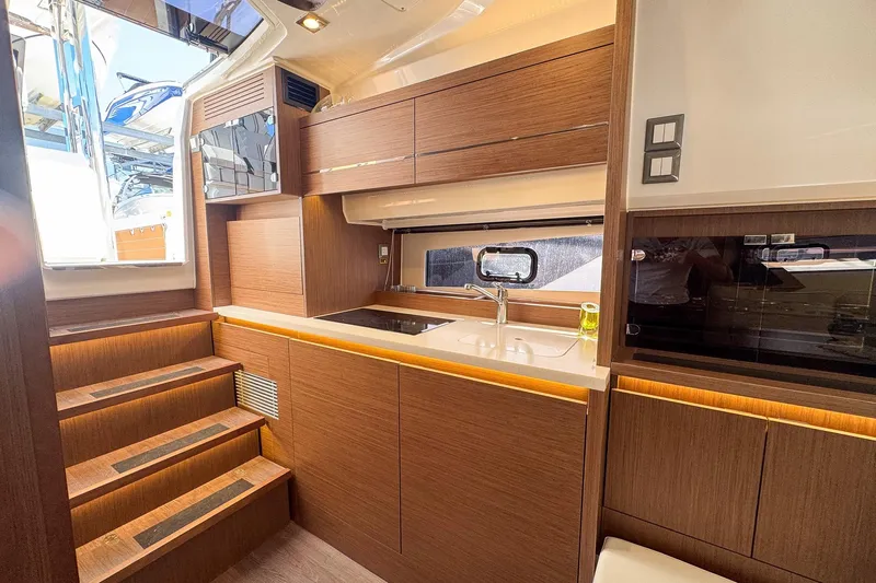 Trade In Yacht Photos Pics Interior of 2022 Jeanneau Leader 12.5 WA yacht, featuring modern kitchen and wooden cabinetry.