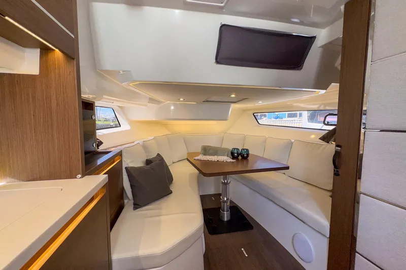 Trade In Yacht Photos Pics Luxurious interior of 2022 Jeanneau Leader 12.5 WA yacht with elegant seating and table.