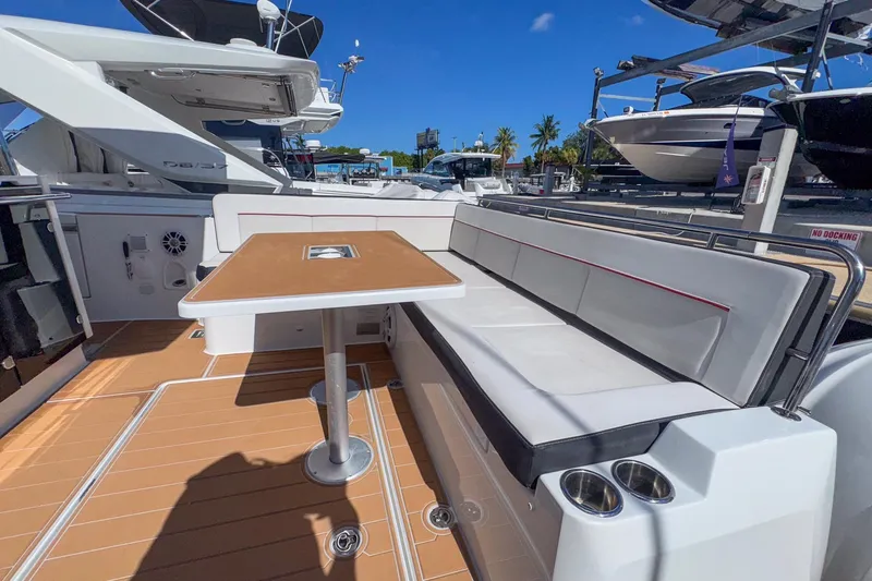 Trade In Yacht Photos Pics 2022 Jeanneau Leader 12.5 WA boat interior with seating and table, docked under clear blue sky.