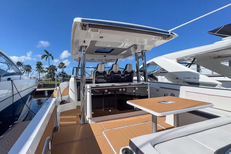 Trade In Yacht Photos Pics 2022 Jeanneau Leader 12.5 WA yacht interior with seating and table, docked under clear blue sky.